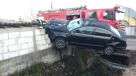 FOTO-VIDEO. Accident spectaculos în Argeș. O șoferiță a rămas suspendată cu mașina pe gardul unei gospodării, după ce a lovit un cal