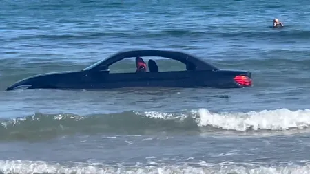 VIDEO | Un BMW a fost luat de valuri și purtat în larg, după ce șoferul l-a lăsat pe plajă. „Nu poți parca acolo, amice”