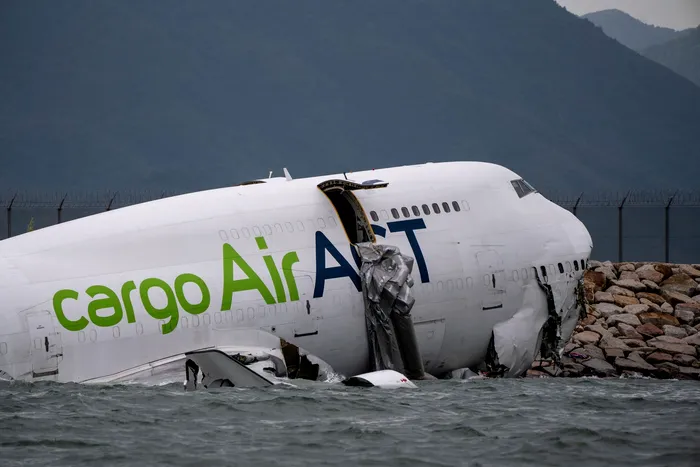 October 20, 2025, Hong Kong, Hong Kong: A cargo plane lies partially in the sea after veering off the runway while landing at Hong Kong International Airport in Hong Kong. The cargo plane has skidded off a runway at Hong Kong International Airport and landed in the sea, killing two persons. The Emirates flight EK9788, a Boeing 747-481 owned by Turkish cargo airline Air ACT, was arriving from Dubai at about 03:50 local time (19:50 GMT) when it hit a vehicle on the north runway. Two airport ground staff fell into the sea, a statement from the Civil Aviation department says. They were rescued but later died in hospital, according to local media including public broadcaster RTHK citing police. Four crew members onboard the plane survived and were taken to hospital.,Image: 1046861942, License: Rights-managed, Restrictions: , Model Release: no, Credit line: Vernon Yuen / Zuma Press / Profimedia