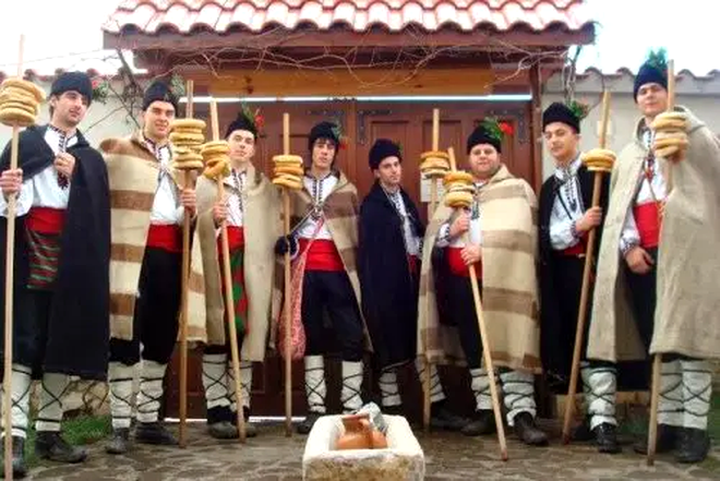 Tineri necăsătoriţi, costumaţi în port popular și care, cu un baston mare din lemn de stejar sculptat cu diferite motive („Koledarka”) 