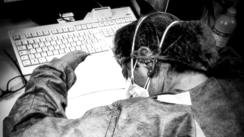 CORONAVIRUS. O asistentă epuizată de munca din spital, surprinsă dormind cu capul pe birou