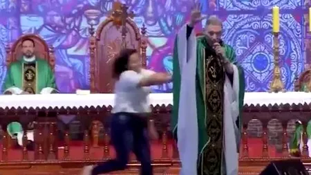 Momentul în care un preot este împins de pe scenă de o enoriașă, după ce ar fi spus că „femeile grase nu ajung în rai