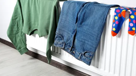 Îți usuci hainele pe calorifer iarna? Ce pericol se ascunde în spatele acestui gest