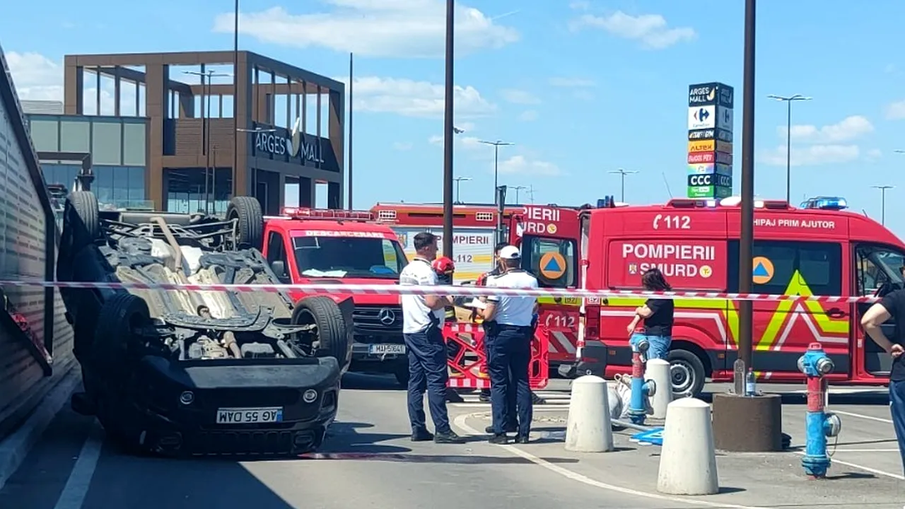 Accident în parcarea unui mall din Pitești. Un pensionar s-a răsturnat cu mașina și a rănit o femeie de 34 de ani