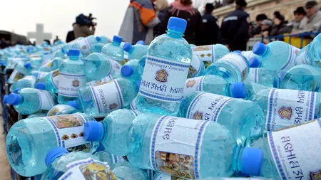 Pregătiri pentru Bobotează. Zeci de voluntari etichetează cele 130.000 de sticle cu aghiasmă ale Arhiepiscopiei Tomisului