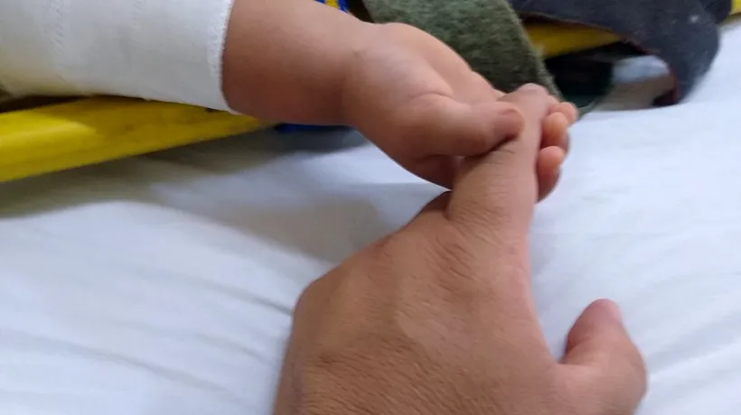 Imagini sfâșietoare: Un bebeluș rămas orfan strânge mâna paramedicului care l-a salvat din accidentul în care și-a pierdut părinții