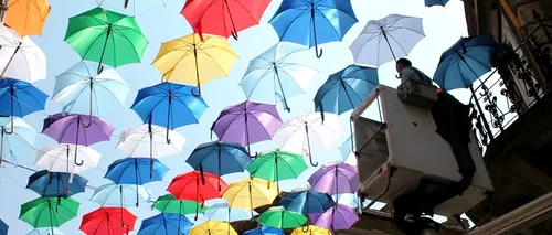 Sute de umbrele multicolore, pe o stradă din Timișoara