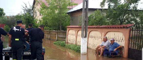 Fotografia zilei, din Teleorman: Localnicii stau pe bancă privind cum pompierii scot apa din comună. Revolta oamenilor pe rețelele de socializare