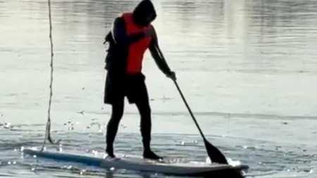 Scene incredibile pe lacul Herăstrău, în ajun de Anul Nou. Un bărbat vâslește pe o placă la -5 grade Celsius