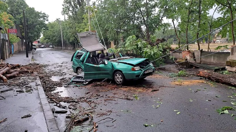 FOTO | La un pas de tragedie în timpul furtunii din Capitală. O mașina aflată în trafic, strivită de un copac căzut. Șoferul, dus direct la spital