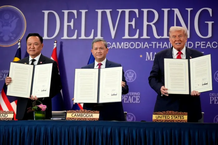 Președintele american Donald Trump, premierul cambodgian Hun Manet (stânga) și premierul thailandez Anutin Charnvirakul afișează documentele semnate în cadrul ceremoniei de încheiere a unui armistițiu la summitul ASEAN din Kuala Lumpur