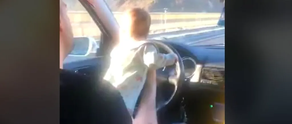 VIDEO | Un șofer a fost filmat în timp ce conducea pe DN7 cu un bebeluș în brațe, pe volan