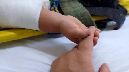 Imagini sfâșietoare: Un bebeluș rămas orfan strânge mâna paramedicului care l-a salvat din accidentul în care și-a pierdut părinții