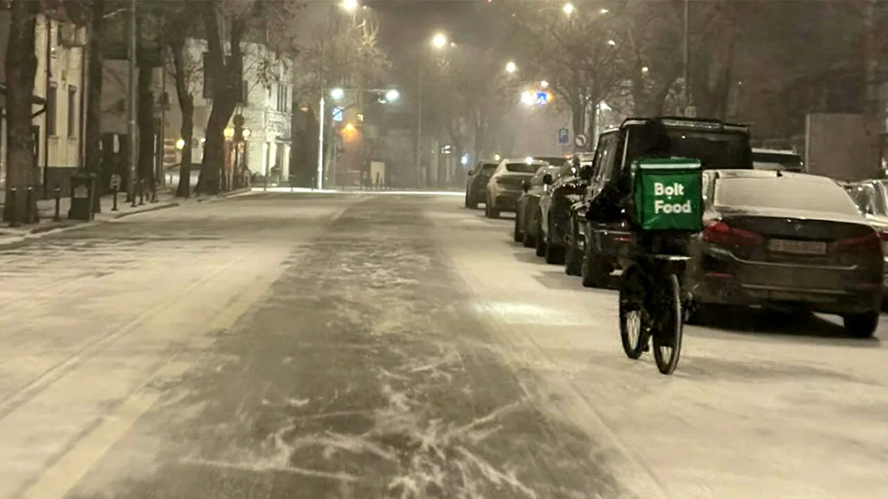 Cum a fost fotografiat acest livrator nepalez noaptea, în timp ce ningea în București. Reacția unei șoferițe