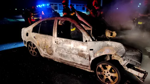 FOTO | O mașină în care se afla o tânără de 21 de ani a ars complet, după ce șoferița a intrat frontal într-un copac