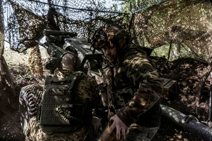 Un soldat ucrainean încarcă tunul de artilerie OTO Melara de 105 mm pentru a trage în direcția orașului Pokrovsk aflat sub ocupație rusească 