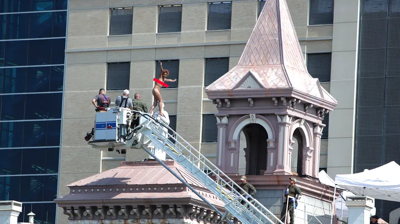 O femeie complet goală s-a urcat pe statuia de pe acoperișul unei catedrale și a stat acolo patru ore | VIDEO