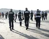 Momentul în care polițiștii francezi intră în apă și găuresc cu cuțitele o barcă de cauciuc plină cu IMIGRANȚI, surprins de reporteri