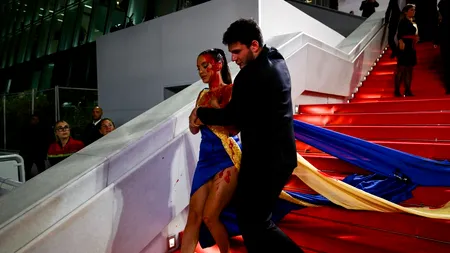 Apariție surprinzătoare pe covorul roșu de la Cannes! O femeie îmbrăcată în culorile Ucrainei a venit acoperită cu sânge fals