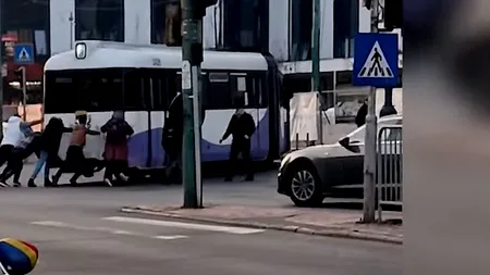 VIDEO | Tramvai împins de călători, după ce a rămas blocat  într-o intersecţie din Timișoara.