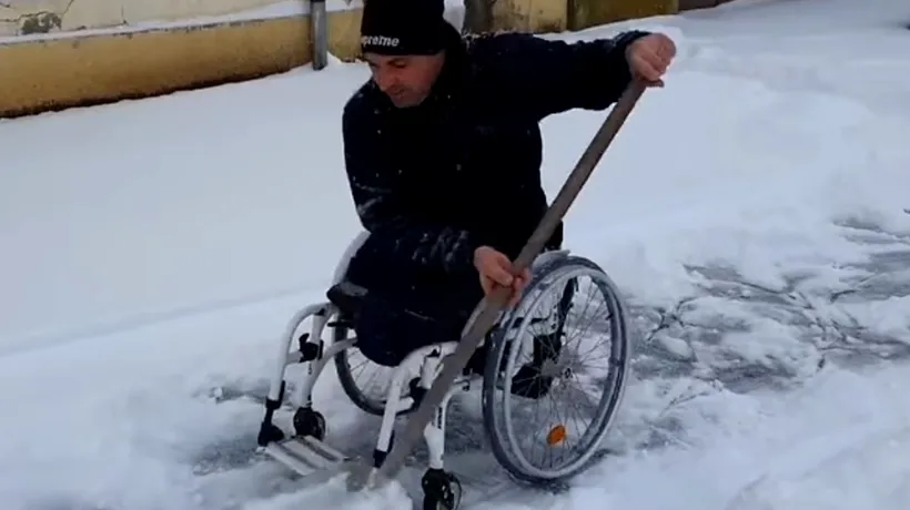 Imagini emoționante! Un bărbat în scaun cu rotile deszăpezește trotuarul din fața casei - VIDEO