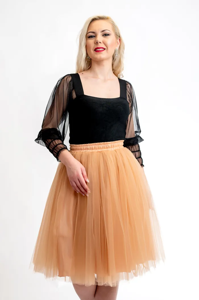Puține piese vestimentare reușesc să transmită, simultan, romantism și forță vizuală așa cum o face fusta de tulle. Asociată adesea cu baletul sau cu ținutele de poveste, aceasta a depășit de mult granițele convenționalului și a devenit un element esențial în garderoba contemporană. Fustele de tulle sunt concepute pentru a oferi mișcare, lejeritate și un efect vizual spectaculos. Secretul stă în stratificarea atent calculată a materialului, astfel încât volumul să fie amplu, dar echilibrat. Nu este vorba despre exces, ci despre proporție. Fiecare strat contribuie la crearea unei siluete armonioase, iar croiala care evidențiază talia accentuează feminitatea într-un mod natural. Aceste piese pot fi integrate cu ușurință în ținute casual-chic – alături de un tricou simplu și pantofi sport pentru un contrast modern – sau în apariții sofisticate pentru evenimente speciale, combinate cu topuri din satin, corsete elegante sau cămăși fine. Versatilitatea lor reflectă perfect dinamica modei actuale, în care granițele dintre stiluri devin tot mai fluide. În plus, faptul că multe dintre modele sunt realizate cu atenție la detalii – de la talia bine definită până la finisajele curate – transformă fiecare fustă într-un statement vestimentar. Este o piesă care nu doar completează o ținută, ci o definește. 