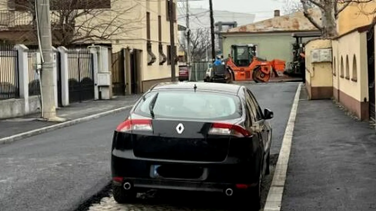 Cum au asfaltat muncitorii din CRAIOVA o stradă pe lângă o mașină parcată. „Am sunat şi la ridicări, dar și ei au întârziat”