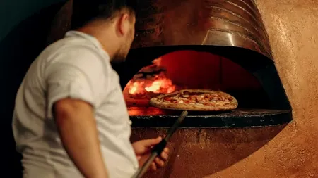 Suma mare de BANI pe care o primește salariu un român care lucrează ca pizzar în Olanda. E plătit săptămânal și are cazarea asigurată!