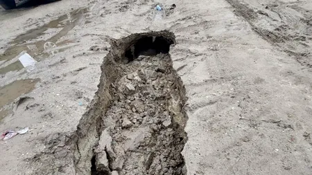 Situație disperată pentru locuitorii din satul Basarabi, județul Dolj. Trei autoturisme și mașina de gunoi au rămas blocate în gropi de un metru