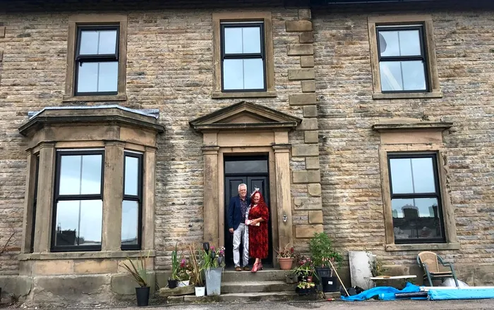 Renovators Joanne Shiels and her partner Geoff Bell outside the mansion. Photo released May 12 2025. A retired couple have transformed a once 'derelict' 140-year-old mansion into a stunning �1 million party house. Joanne Shiels, 60, and her partner Geoff Bell, 61, bought the crumbling Greystonedale Mansion in Haltwhistle, Northumberland, for �300,000 in May 2022. Over next 24 months they gave the eight bedroom property some much-needed TLC investing �220,000 for a complete refurbishment. They fitted it with its very own �disco kitchen�, a games room, and a replanted the one-acre private garden - it also fits up to 14 guests.,Image: 998380850, License: Rights-managed, Restrictions: Editorial use, commercial use may require additional licenses. We don't use AI to make images which could be mistaken for news photos. AI use will be clearly indicated. Supplied on condition you ensure personal data is processed in compliance with UK GDPR, Model Release: no, Credit line: Courtesy Joanne Shiels / SWNS / SWNS / Profimedia