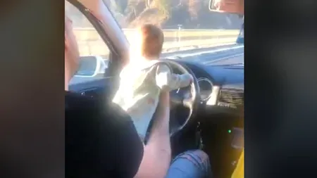 VIDEO | Un șofer a fost filmat în timp ce conducea pe DN7 cu un bebeluș în brațe, pe volan