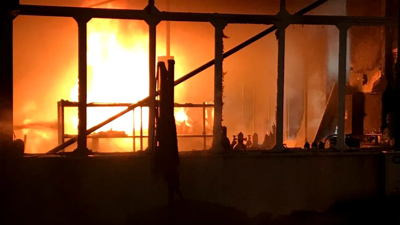 Incendiu de proporții la un service auto. Au ars șapte mașini și o remorcă FOTO