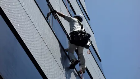 La un pas de tragedie. ALPINIST utilitar aflat la etajul 11 al unui bloc, dezechilibrat de o locatară care trăgea cu putere de corzi