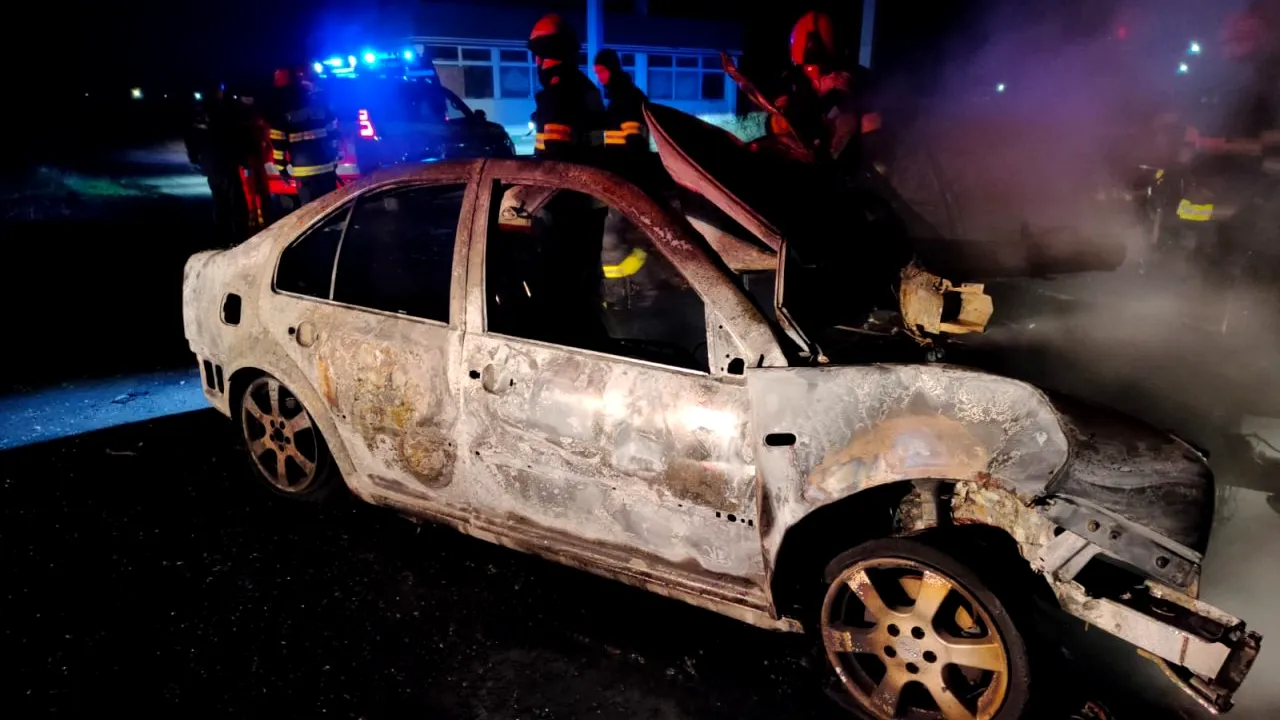 FOTO | O mașină în care se afla o tânără de 21 de ani a ars complet, după ce șoferița a intrat frontal într-un copac