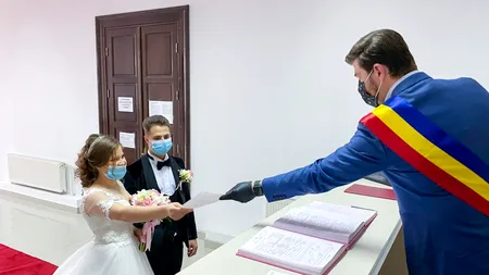 FOTO. Nuntă în vreme de coronavirus. Doi tineri au venit cu măștile pe față ca să spună ”DA”
