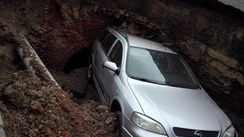 O groapă din asfalt a înghițit o mașină aflată într-o parcare din Râmnicu Sărat. Ce se afla în interiorul craterului format