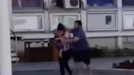 Preot filmat în timp ce își bate soția pe stradă, în plină zi, la Bacău. Femeia are copilul în brațe (VIDEO)