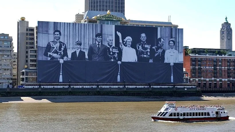 Un banner uriaș cu imaginea Familiei Regale britanice, desfășurat  pe cheiul Tamisei