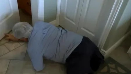 Un bătrân cu handicap sever, nevoit să se târască pe holul hotelului, după ce agenții de pe aeroport i-au confiscat acumulatorii de la scaunul rulant