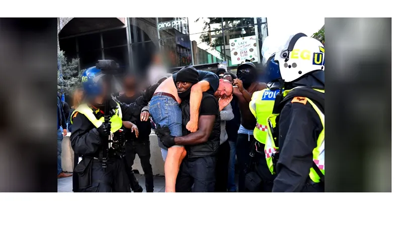 PROTESTE. Un bărbat de culoare, surprins în timp ce salvează un protestatar alb
