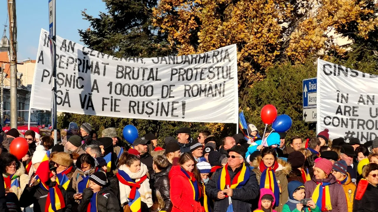 CINSTE înaintașilor! RUȘINE nouă! În an CENTENAR, România are un premier AGRAMAT controlat de UN INFRACTOR. Mesaje de PROTEST față de Jandarmerie și PSD, la defilarea de la Cluj