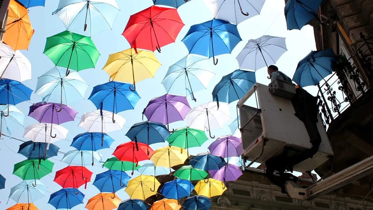 Sute de umbrele multicolore, pe o stradă din Timișoara