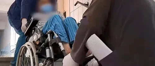 VIDEO | Scene revoltătoare într-un spital din Reșița! Pacienții imobilizați sunt cărați pe brațe de infirmieri pentru că în clădire nu există lift