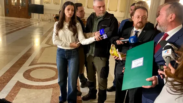 Ilie Bolojan, așteptat în Parlament cu banane și un catalog improvizat, în care premierul a primit nota trei de la Opoziție