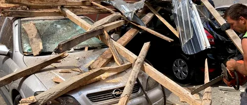 FOTO-VIDEO | Un acoperiș smuls de vânt a căzut peste mai multe mașini, într-o localitate din Alba. Județul se află sub cod portocaliu de instabilitate atmosferică