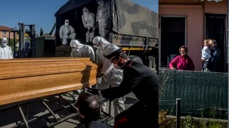 IMAGINI TULBURĂTOARE. O famile își ia rămas bun de la un membru, băgat cu un sicriu în camionul de armată