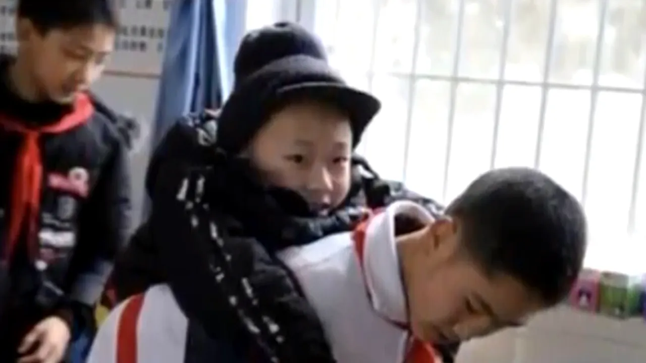 Dovada adevăratei prietenii. Un băiat de 12 ani îl cară în spate pe amicul său care nu poate merge - VIDEO