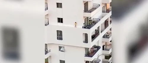 O fetiță a fost surprinsă în timp ce se plimba pe un perete al unui bloc, la etajul cinci. Ce făcea mama în acel timp VIDEO