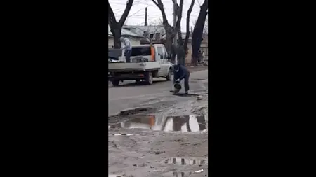 De necrezut. Pe o stradă din Brăila se toarnă asfalt direct în gropile pline cu apă (VIDEO)