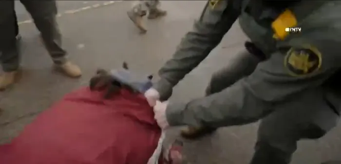 Un agent federal pune la pământ și târăște o manifestantă